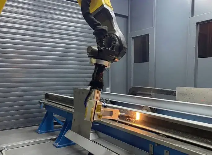 Robot performing laser surface treatment on a steel profile